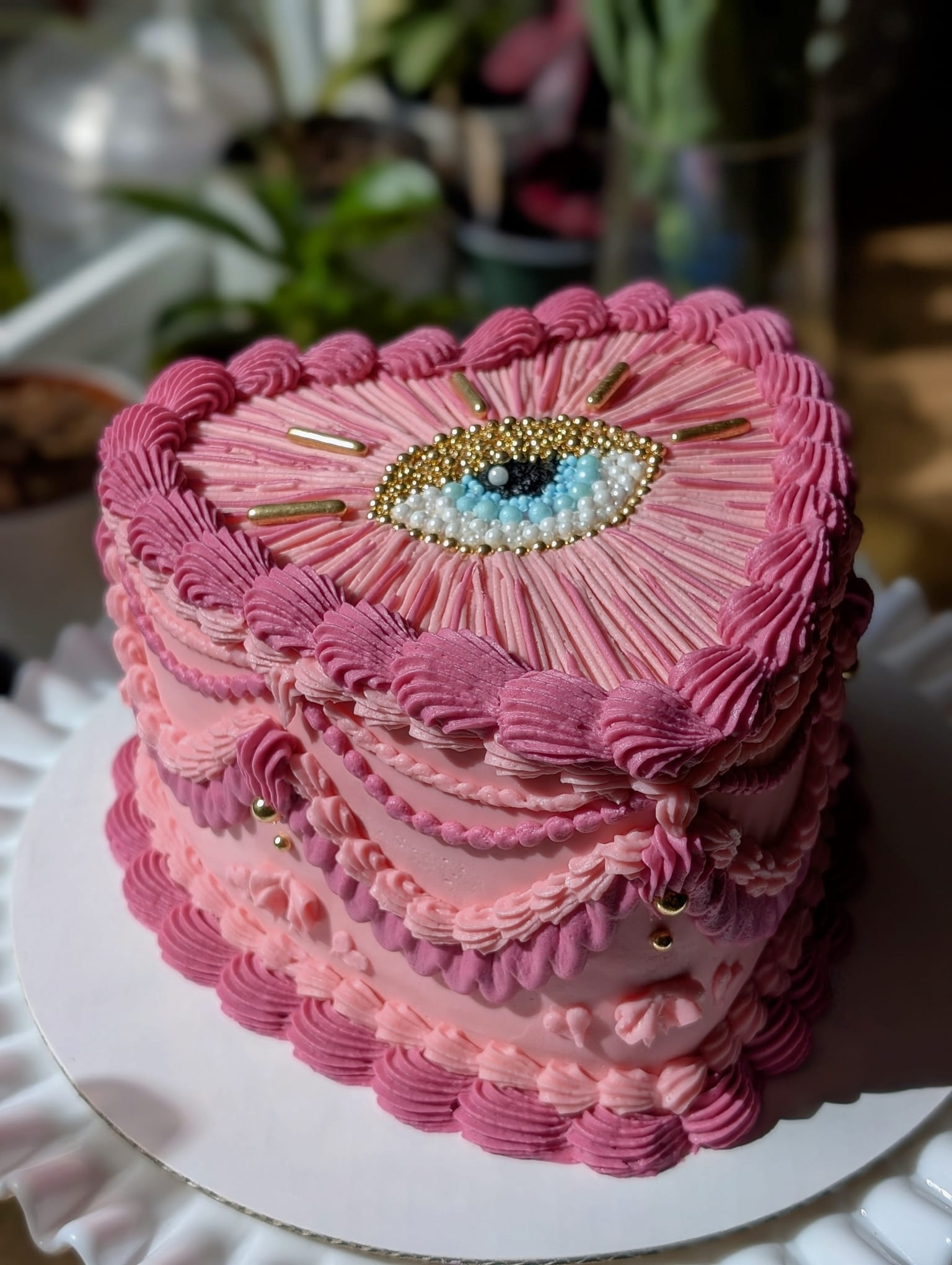 Pink heart cake with an embroidery-inspired evil eye design