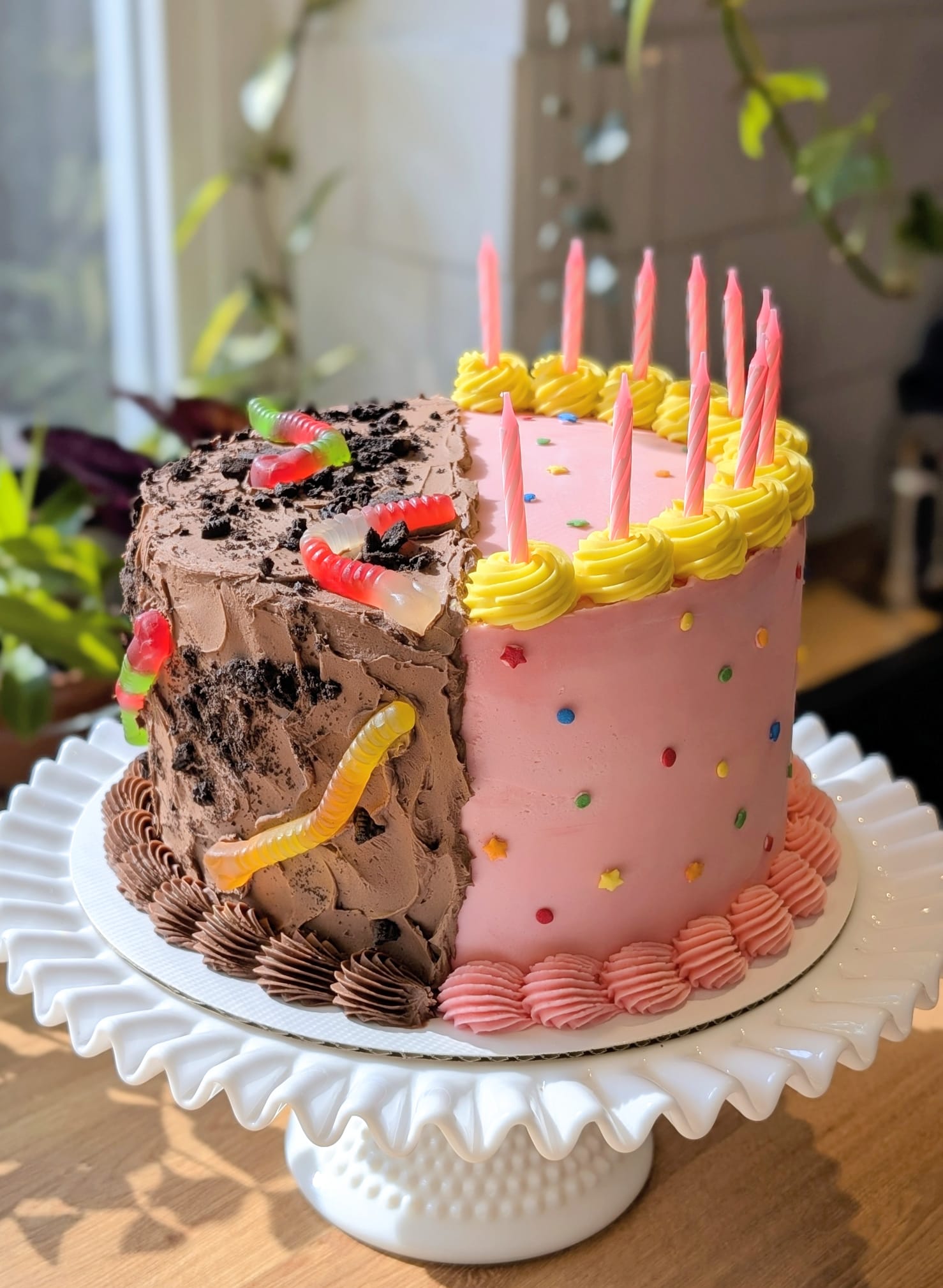 Half chocolate dirt and gummy worms, half pink sprinkle birthday cake
