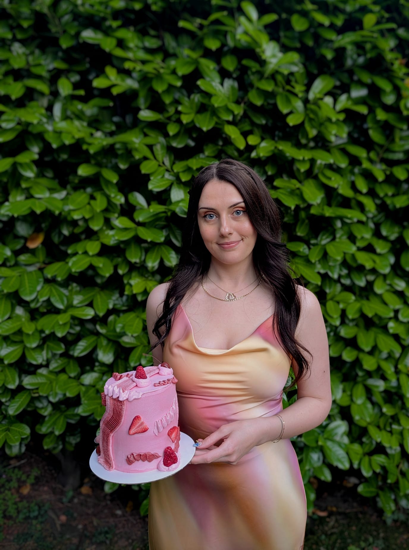 Kyran holding one of her pink berry cakes
