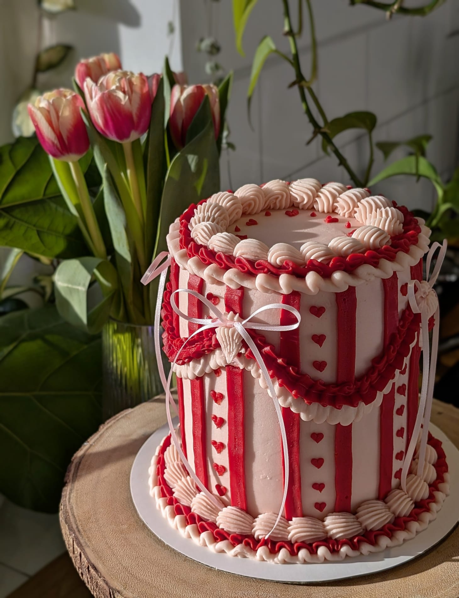 Red and pink striped cake with ruffles, bows and hearts